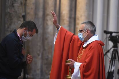 El rector de la catedral, Emmanuel Blondeau,  da la comunión a un fiel en la misa de Pentecostés celebrada en Notre Dame.