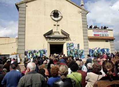 Cientos de personas siguen la misa del Domingo de Resurrección en el exterior de la parroquia de San Carlos Borromeo. 

.