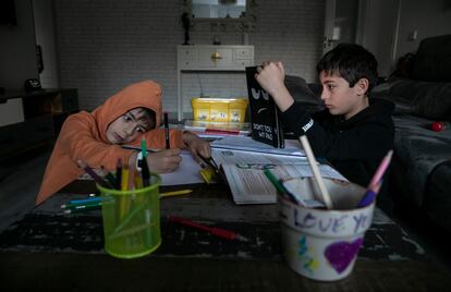 Dos niños estudiando en una casa de Madrid.