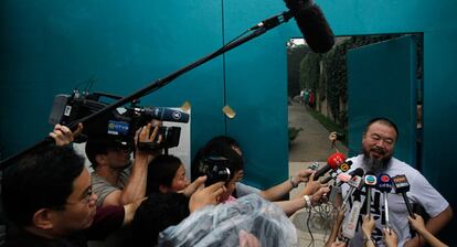 El artista chino Ai Weiwei habla con los periodistas que se han reunido hoy a las puertas de su casa en Pekín.