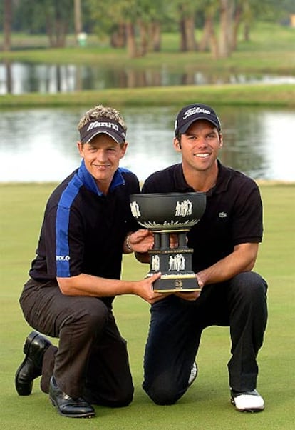 Luke Donald (a la izquierda) y Paul Casey posan, felices, con el trofeo de la Copa del Mundo.