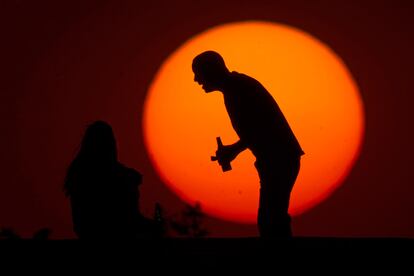 Um casal desfruta de um pôr do sol em Brasília, em 15 de agosto de 2014.