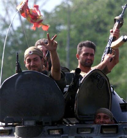 Soldaos macedonios saludan haciendo un gesto tradicional ortodoxo mientras saludan a las afueras de Skopje