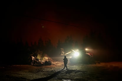 Los agricultores cargan alimentos para animales rodeados de humo en Piedrafita (Asturias), el viernes.