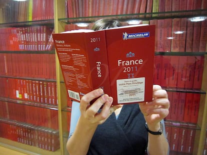 Juliane Caspar, in an archive photograph, with her face covered by a copy of the 2011 Michelin Guide.