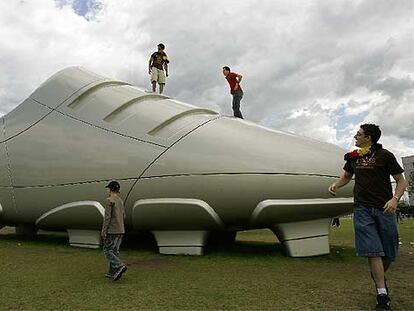 Un grupo de jóvenes se encarama a un bota gigante en Berlín.