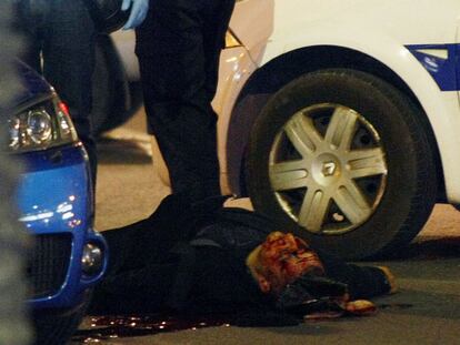 El atracador muerto, rodeado de policías.