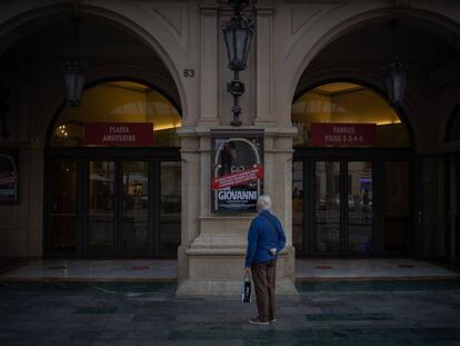 Un home mira el cartell de l'òpera 'Don Giovanni' a la porta del Liceu, amb les funcions cancel·lades per les restriccions decretades per la Generalitat.