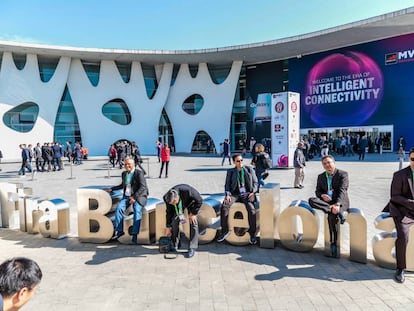 Asistentes al Mobile World Congress de 2019 se toman un descanso en los exteriores de la Fira de Barcelona.