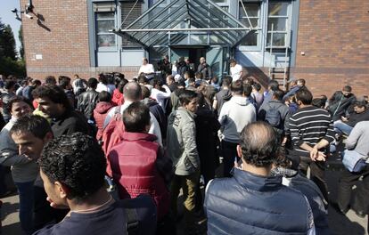 Un grupo de refugiados hace cola para registrarse en la Oficina Federal de Migración y Refugiados del distrito de Spandau, en Berlín, durante la visita de la canciller Angela Merkel.