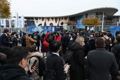 Decenas de visitantes esperan en el exterior del MWC durante la jornada inaugural que se celebra este lunes en Barcelona.