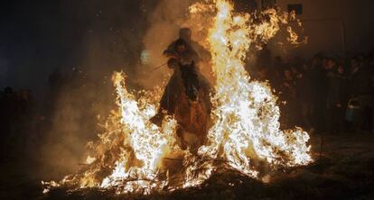 Un hombre y su hijo atraviesan las llamas montados en un caballo
