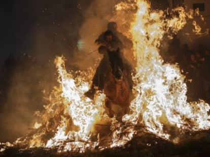 Un hombre y su hijo atraviesan las llamas montados en un caballo