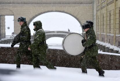 Jóvenes músicos militares caminan en mitad fuerte nevada para asistir a un ensayo con motivo del desfile militar del 27 de enero, cuando se conmemora el 75 aniversario del levantamiento del sitio nazi de Leningrado, en San Petersburgo. 