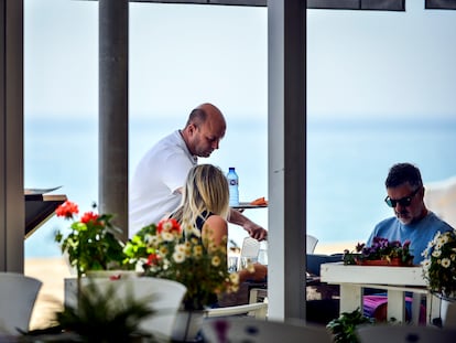 Un camarero atiende a una pareja en la terraza de un restaurante del Paseo Marítimo de Playa de Aro (Costa Brava-Girona) /Toni Ferragut