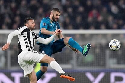 El delantero del Real Madrid Karim Benzema lucha por hacerse con el balón ante Andrea Barzagli, de la Juventus.