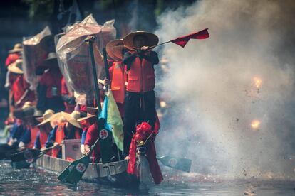 Un grupo de remeros realiza un espectáculos con pirotecnia durante una carrera de barcos de dragón, en Guangzhou, China.