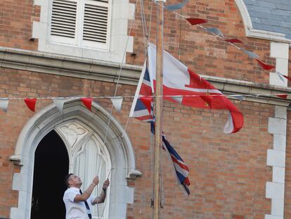 GIBRALTAR, 08/09/2022.- Un funcionario de la sede del gobernador en Gibraltar coloca las banderas a media asta con motivo del fallecimiento hoy jueves de la reina Isabel II de Inglaterra. EFE/A.Carrasco Ragel.
