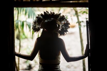 Txai Suruí using a cocar, a traditional garment