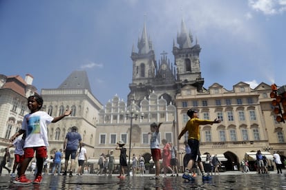 Los niños se refrescan en la fuente de la Plaza de la Ciudad Vieja de Praga, República Checa, el 25 de junio de 2019. 