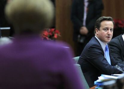 Cameron mira a Merkel (de espaldas) en la cumbre europea.