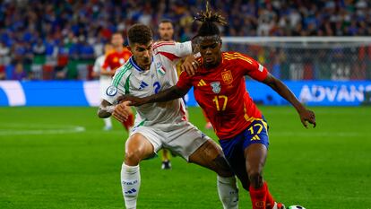 El delantero de la selección española, Nico Williams protege el balón ante el defensa de la selección italiana durante el encuentro de la fase de grupos de la Eurocopa 2024.
