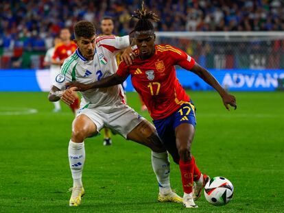 El delantero de la selección española, Nico Williams protege el balón ante el defensa de la selección italiana durante el encuentro de la fase de grupos de la Eurocopa 2024.