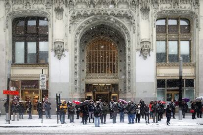 Varias personas esperan su autobús bajo la nieve en Nueva York.