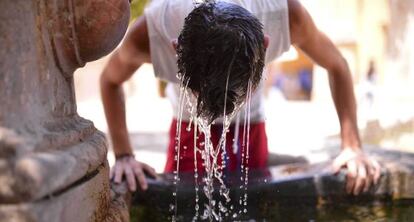 Un joven se refresca en una fuente de la Mezquita de Córdoba.
