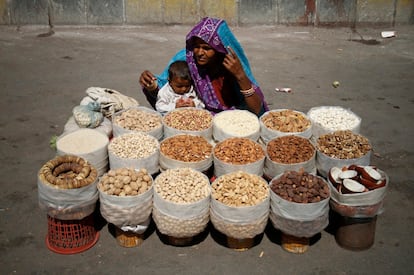 Una mujer vende frutos secos con su hijo en la calle de Karachi, la mayor ciudad y la capital económica de Pakistán.