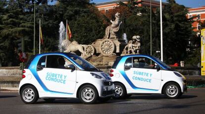 Coches de la flota de Car2go pasando por La Cibeles.