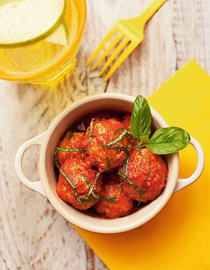 <p><i> Ingredientes</i></p><p> Para 4 personas: Para la salsa, 1 kilo de puré de tomate (tipo passata), 1 cebolla grande, 2 dientes de ajo, 12 hojas de albahaca genovesa (la de hoja grande), aceite de oliva virgen extra, sal, pimienta, azúcar (opcional). Para las albóndigas, 350 gramos de carne de cerdo picada (jamón o cabeza de lomo), 350 gramos de carne de ternera picada (preferiblemente elegir jarrete o falda), 2 dientes de ajo, 100 gramos de pan seco, leche entera, 2 huevos, sal, pimienta, perejil fresco. </p><p><i> Preparación</i></p><p> 1. Poner en una olla ancha con un fondo de aceite la cebolla, pelada y picada, a fuego medio. Cuando empiece a dorarse, añadir los ajos picados muy finos. Añadir el tomate, un poco de sal y pimienta, bajar el fuego y dejar cocinar sin tapar para que evapore. 2. Trocear el pan, mojarlo con la leche y, una vez hidratado, escurrirlo ligeramente. Mezclar la carne con el pan, el ajo picado muy fino, dos cucharadas de perejil fresco triturado y los dos huevos. Salpimentar y trabajar la mezcla hasta que esté integrada. 3. Cuando la salsa esté lista (unos 25 minutos), probarla para saber si ha quedado ácida, y rectificar con una punta de azúcar si hace falta. 4. Hacer bolitas con la carne picada y ponerlas sobre la salsa. Tapar y cocinar a fuego lento unos 15 minutos, añadiendo la albahaca picada casi al final. Servir calientes.</p>