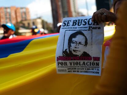 Un manifestante en contra del Gobierno de Gustavo Petro sostiene un cartel con el retrato del presidente en la plaza de Bolívar, en Bogotá (Colombia).