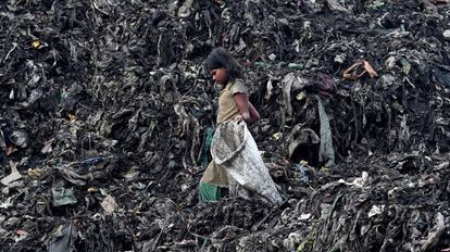 Una niña busca entre la basura de un vertedero en Guwahati (India) en una image de este lunes.