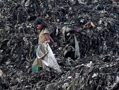 Una niña busca entre la basura de un vertedero en Guwahati (India) en una image de este lunes.