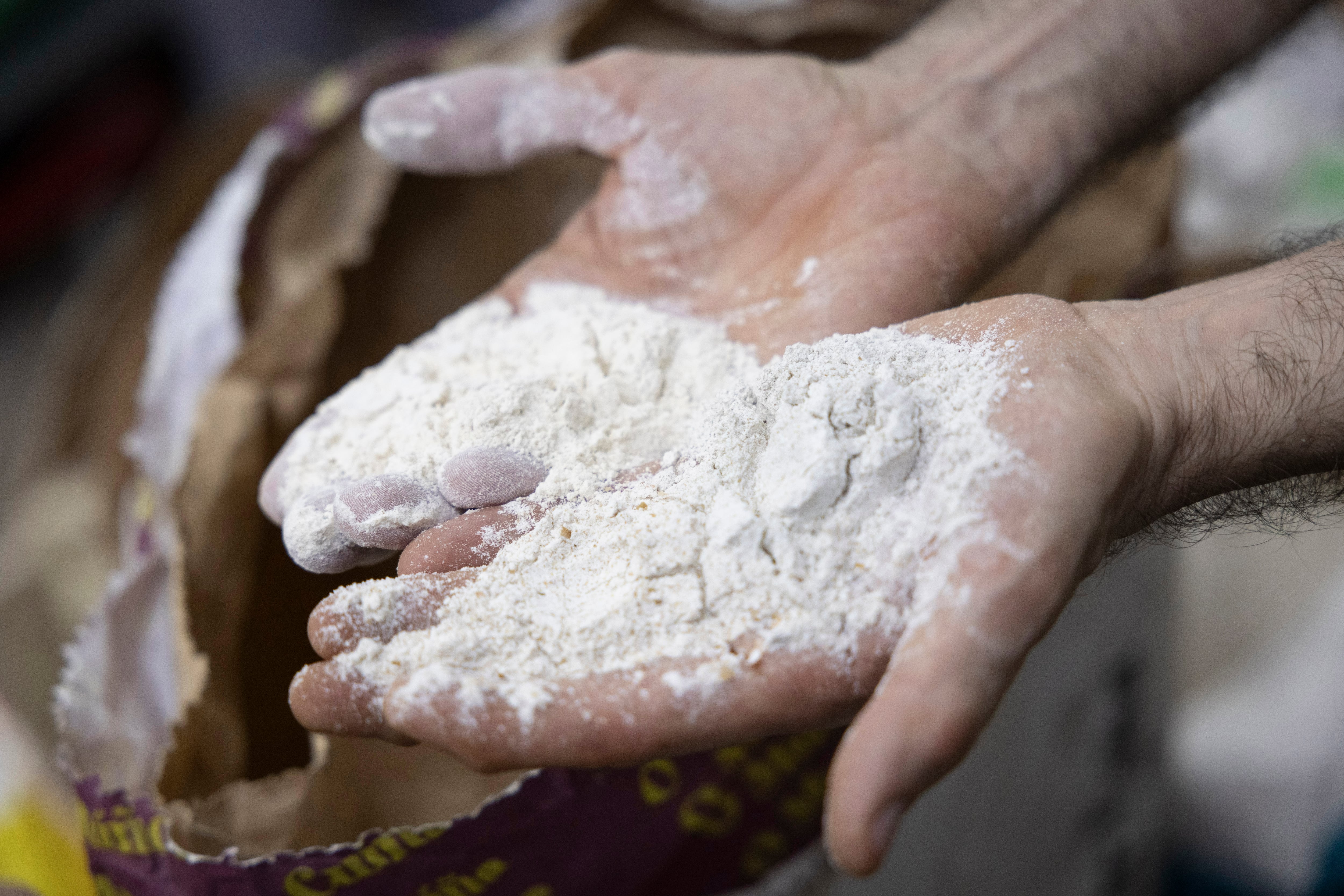 El panadero Daniel Jordà manipula una de las harinas que emplean para amasar su producto. 