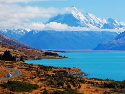 Una caravana serpenteando por la carretera, bordeando el Lago Pukaki. De fondo, el Monte Cook, en Nueva Zelanda.