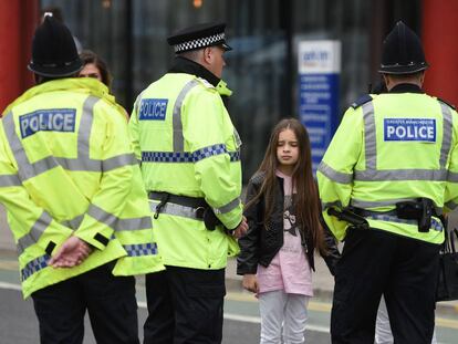 Agentes de la policía dan información a una madre, que permanece junto a su hija, tras el ataque terrorista en el Manchester Arena.