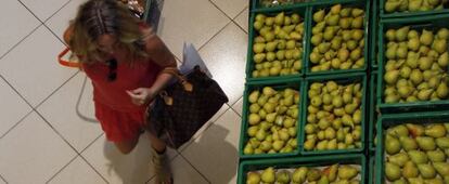 Una mujer compra frutas y verduras en un supermercado.