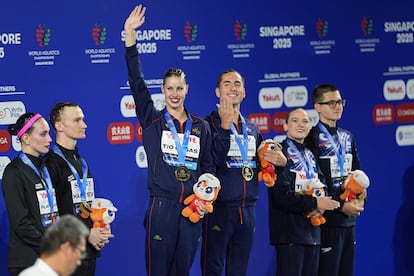 De izquierda a derecha, los medallistas de plata, los atletas neutrales Aleksandr Maltsev y Olesia Platonova; los medallistas de oro, Dennis Gonzalez Boneu e Iris Tio Casas de España; y los medallistas de bronce, Isabelle Thorpe y Ranjuo Tomblin de Gran Bretaña, posan en el podio tras la final de dúo mixto libre de natación artística en el Campeonato Mundial de Deportes Acuáticos, en Singapur.