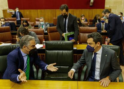 El presidente andaluz, Juan Manuel Moreno (derecha), y el consejero de la Presidencia, Elías Bendodo, en sus escaños al comienzo del pleno del Parlamento de Andalucía que se ha celebrado este miércoles en Sevilla.
