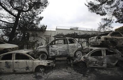 Carros incendiados se amontoam ao longo de uma estrada em Mati