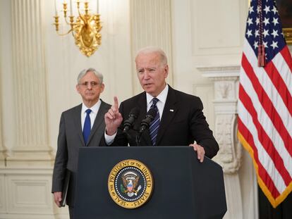 El fiscal general de EE UU, Merrick Garland, observa al presidente Joe Biden mientras se dirige a la nación.