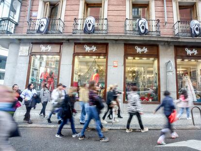 Varias personas pasan por delante de una tienda del centro de Madrid el 31 de octubre.