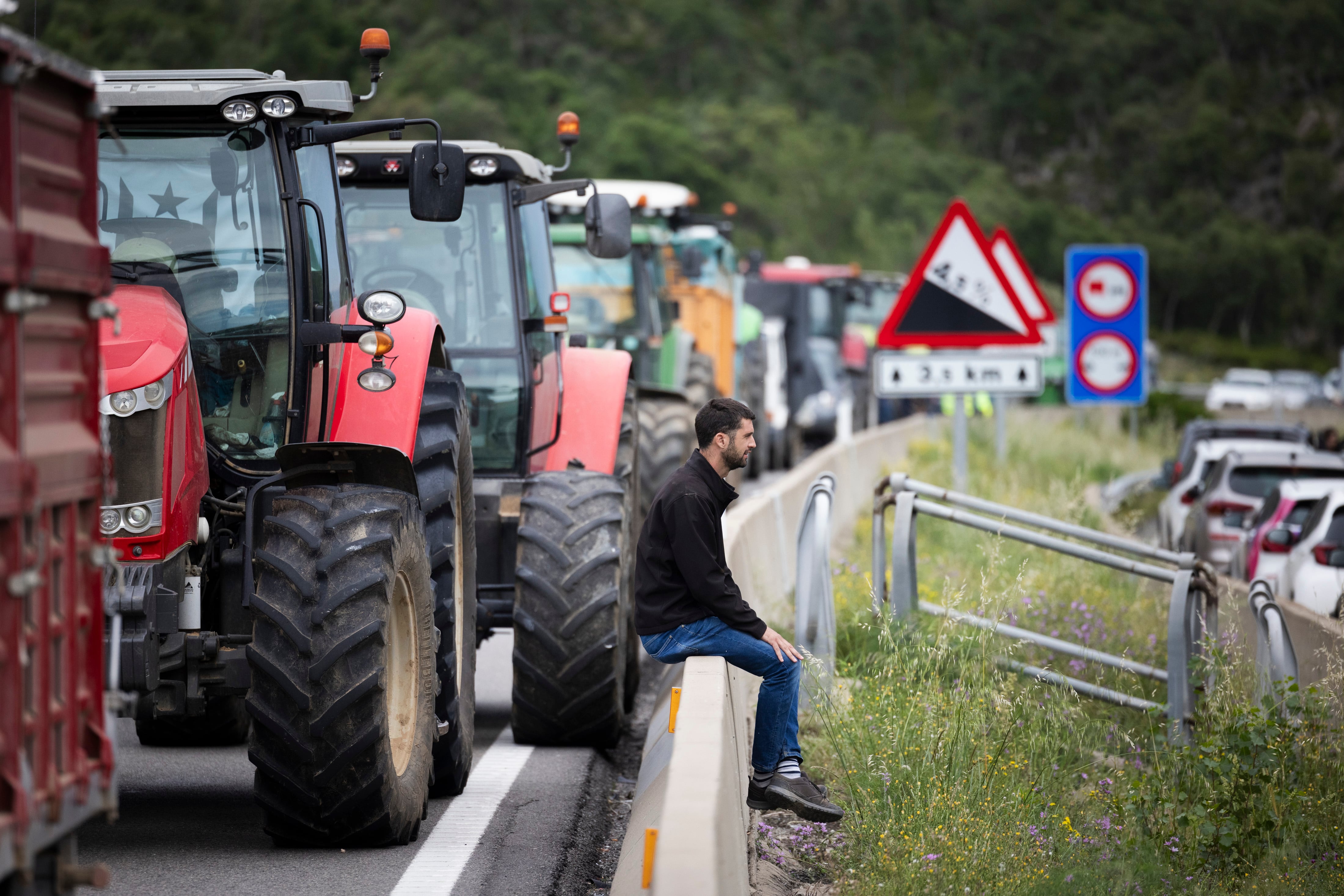 Un hombre junto a un tractor durante el bloqueo de la AP-7 este lunes, en La Jonquera (Girona).