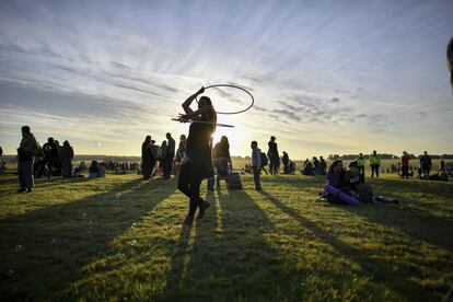 Una mujer baila con un hula-hoop durante el amanecer en Stonehenge, en Salisbury (Reino Unido).