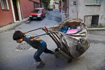 Un gran numero de habitantes de Tarlabasi viven de la recogida, reciclado y procesado de materiales que obtienen del céntrico barrio de Beyoglu. En la imagen un muchacho empuja un carro de material reciclado.