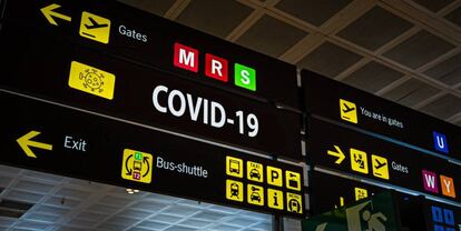 Carteles indicadores en un aeropuerto con la alerta del Covid-19.