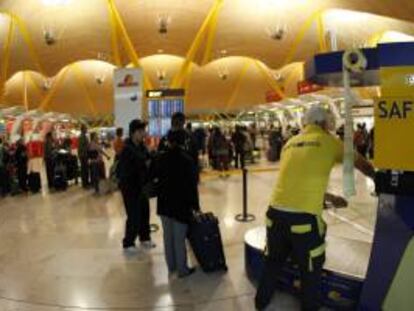 Decenas de personas guardan su turno para facturar las maletas en la T4 del Aeropuerto de Barajas. EFE/Archivo