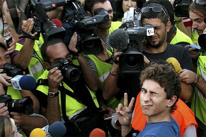 Jorge Lorenzo hace la señal de la victoria rodeado de cámaras de medios de información a su llegada al aeropuerto de Palma de Mallorca.